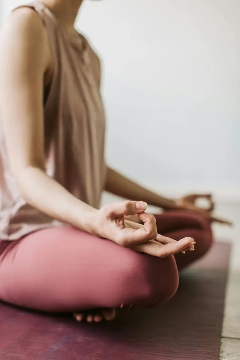 Personne assise en méditation sur un tapis de yoga