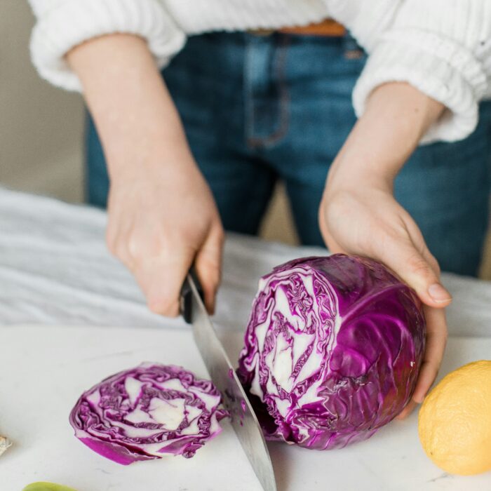 Femme préparant des légumes frais dans le cadre d'une alimentation holistique pour retrouver l'énergie