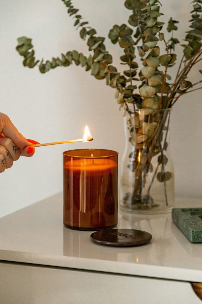 Main allumant une bougie dans un espace de consultation nutrition pour la fatigue, Annam Nutrition Suisse